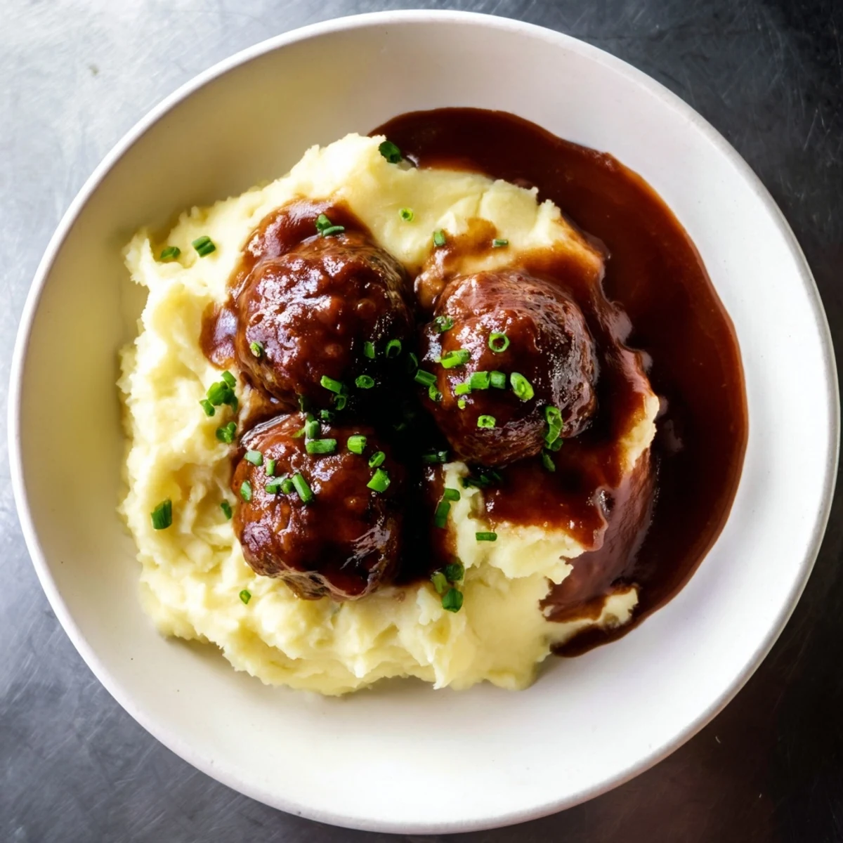 Warm, tender BBQ meatballs smothered in sauce, served with perfect mashed potatoes in this recipe.