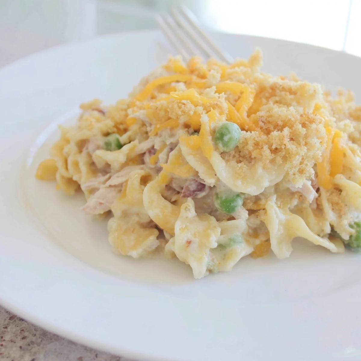 Golden, bubbly Creamy Tuna Noodle Casserole with a crispy Ritz cracker topping, ready for serving.