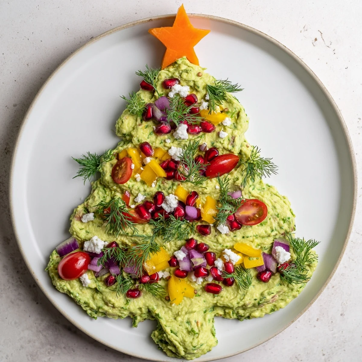 Creamy whipped avocado Christmas tree dip decorated with colorful festive, fresh vegetables, ready to serve.