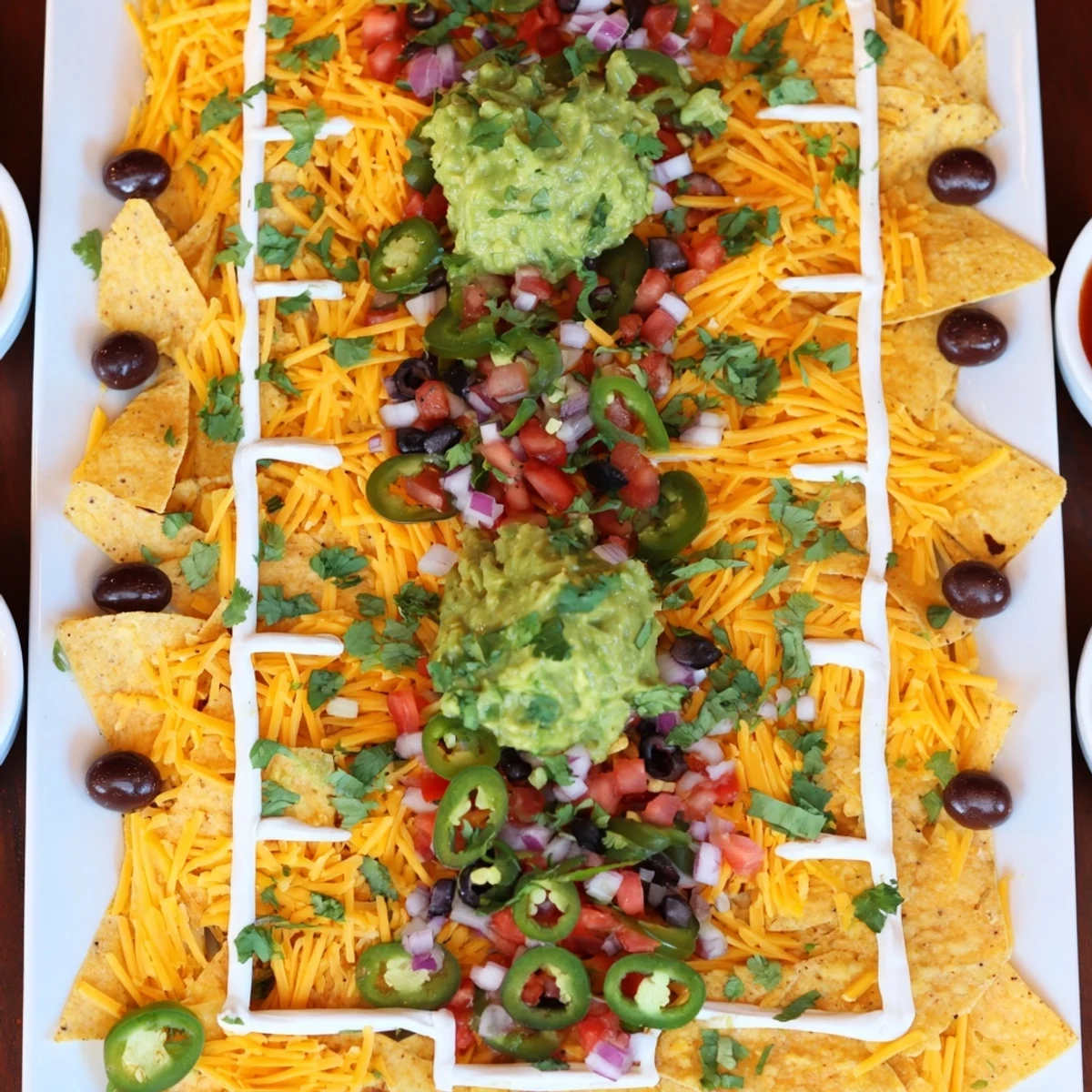 Golden, cheesy Football Field Nacho Platter, perfect for sharing and layered with savory toppings.