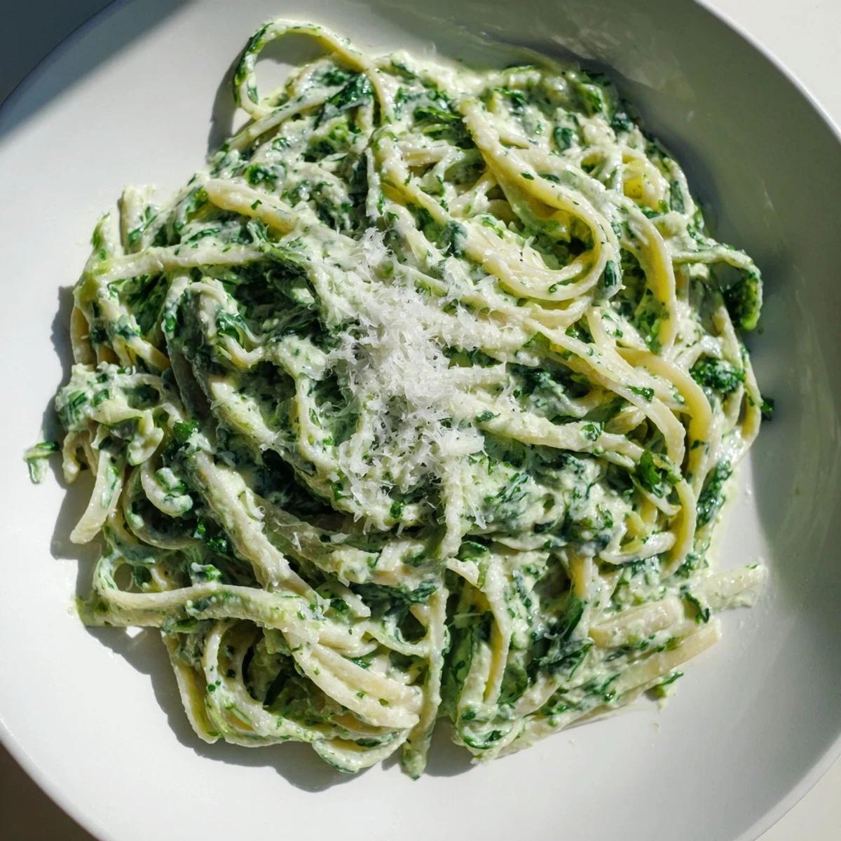 Linguine pasta in creamy Green Goddess Pasta Sauce, garnished with fresh herbs and Parmesan cheese.