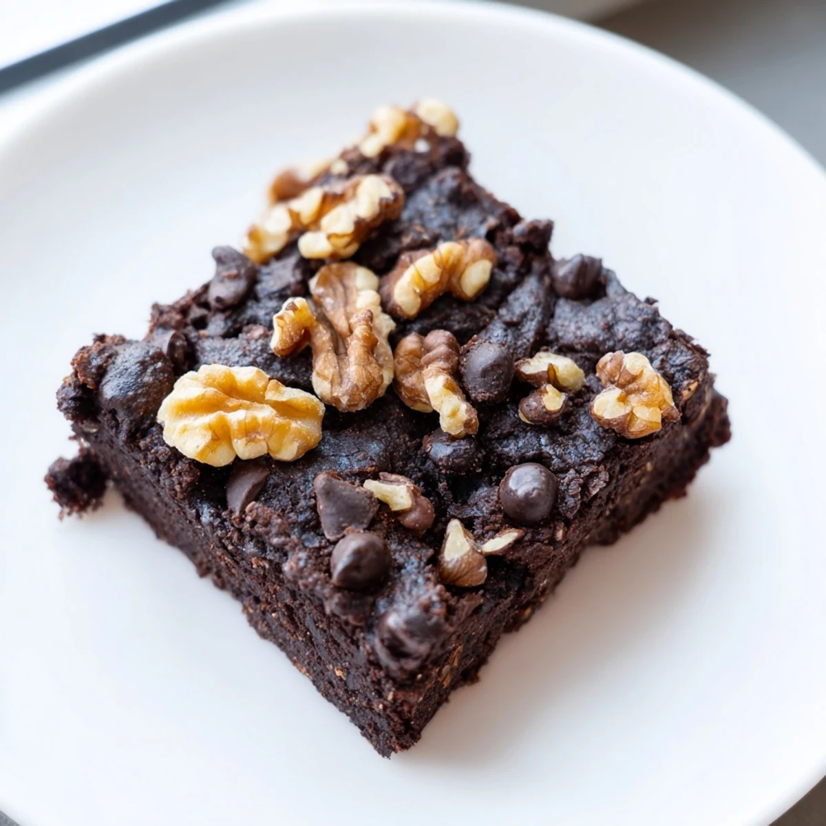 Gooey black bean brownies are topped with chocolate chips, a delicious gluten-free dessert option.