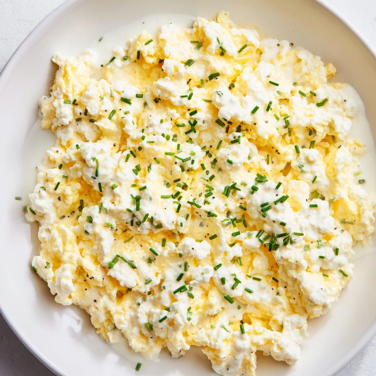 Fluffy Cottage Cheese Scrambled Eggs, a protein-packed breakfast, looks creamy and delicious on a plate.