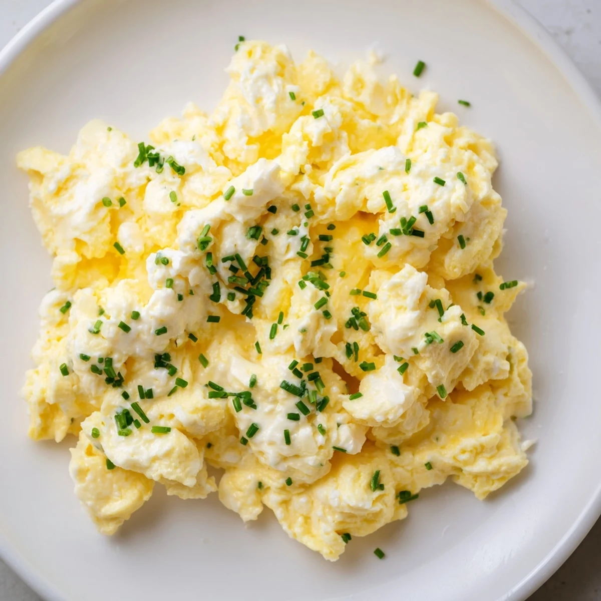 Golden Cottage Cheese Scrambled Eggs with fresh herbs, ready for a flavorful and easy breakfast.