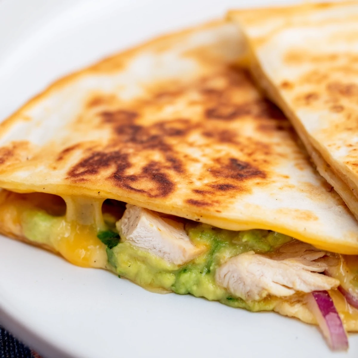 Crispy golden tortilla filled with juicy grilled chicken and creamy avocado mash in this Chicken Avocado Quesadilla.