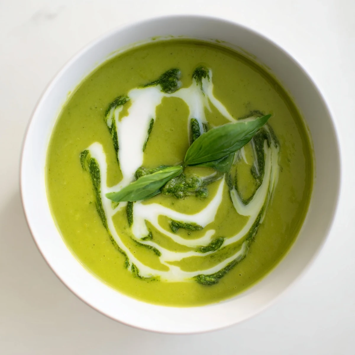 Hearty courgette, pea and pesto soup served hot, garnished with fresh basil.