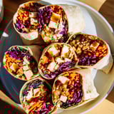 Close-up of a sweet chili tofu crunch wrap, showcasing layers of texture and flavor vividly.