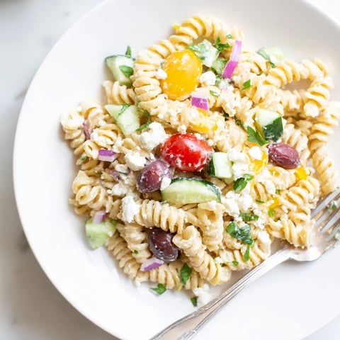 A colorful bowl brimming with Greek Yogurt Million Dollar Christmas Pasta Salad, creamy and refreshing.