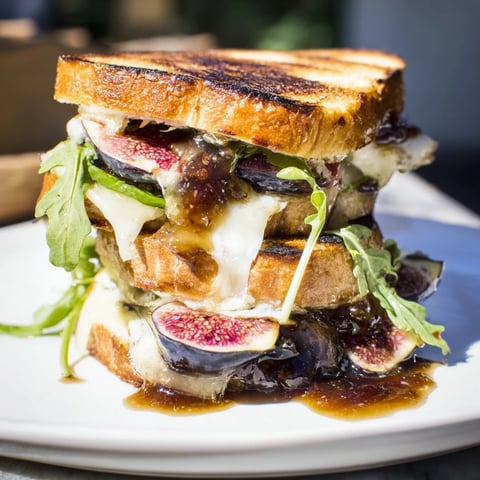 Golden-brown Fig, Brie & Arugula Grilled Cheese, oozing melted Brie with peppery arugula.