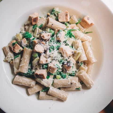 Steaming Creamy Spinach Artichoke Protein Pasta Skillet, a one-pan meal with bubbly cheese and tender spinach.