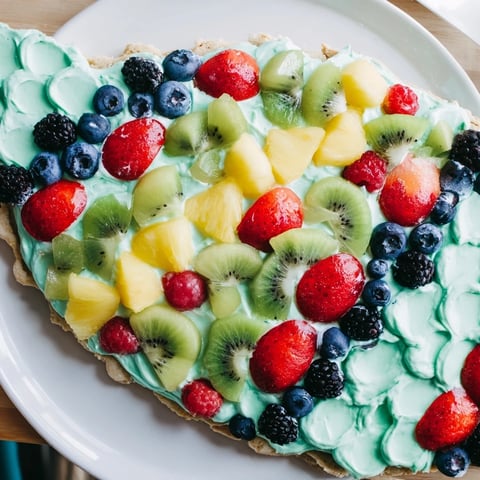 Vibrant Under the Sea Mermaid Tail Fruit Pizza, with colorful fruit arranged on a creamy frosted sugar cookie.