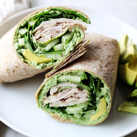 Green Goddess Wellness Wrap displays fresh ingredients, with creamy avocado and shredded chicken visible.