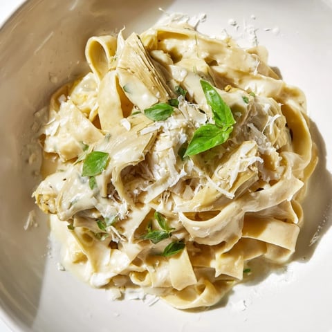 Creamy Lemon Artichoke Pasta: A vibrant photo shows the luscious pasta with tender artichokes and fresh herbs.
