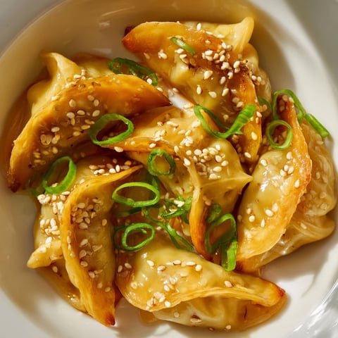 Golden-brown Air Fryer Frozen Dumplings, crispy outside and tender inside with savory sesame glaze.