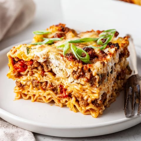 Delicious spicy ramen lasagna, topped with bubbling mozzarella and fresh green onions.  
