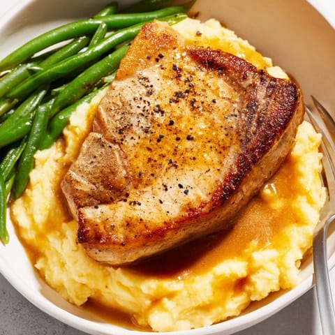 Comforting pork chops and cheddar mash bowl topped with crisp green beans.  