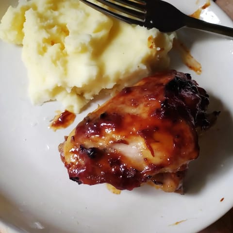 Oven-baked honey BBQ chicken thighs glazed richly, paired with fluffy garlic mashed potatoes.  