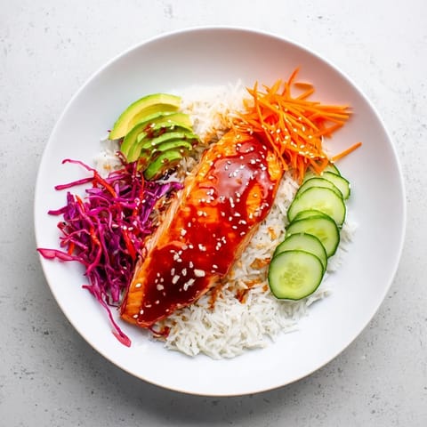 Tender, flaky sweet chili salmon atop fluffy rice, a complete and flavorful rice bowl meal.