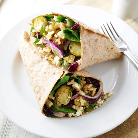 Close-up of a Roasted Brussels Sprouts & Cranberry Grain Wrap, showcasing colorful fillings and textures.