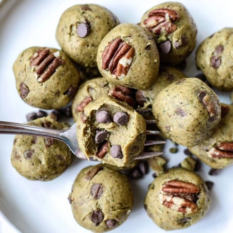 Vibrant image of Matcha Gingerbread Cookie Dough Protein Bites, studded with chocolate chips, delicious and healthy.