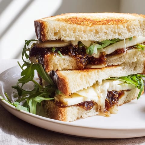 Crispy sourdough filled with creamy Brie, fig, and arugula: a fancy grilled cheese creation.