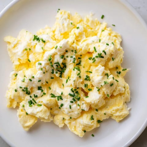 Golden Cottage Cheese Scrambled Eggs with fresh herbs, ready for a flavorful and easy breakfast.