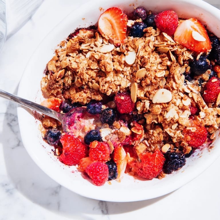 Homemade Berry Oat Crumble showing a scoop, fresh from the oven for sharing.