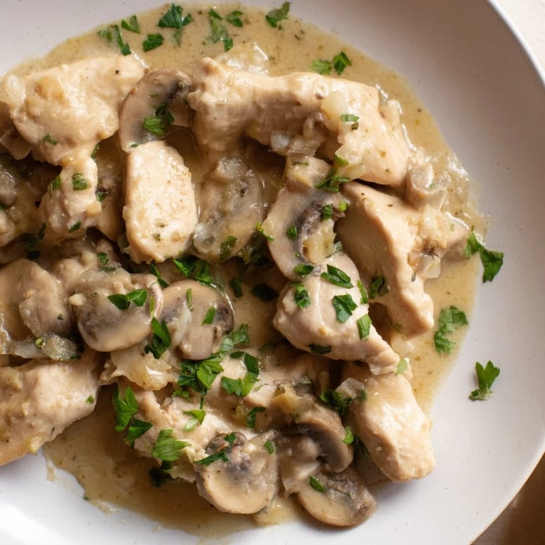 A steaming bowl of Creamy Chicken Stroganoff with fresh parsley garnish, ready to serve over fluffy noodles.