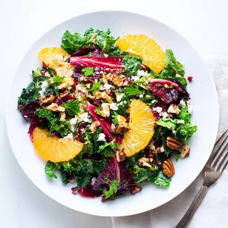 A delicious bowl of Winter Greens Salad with ruby pomegranate seeds, perfect for a light vegetarian meal.