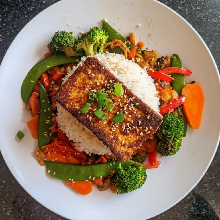Perfectly seared tofu steaks with a flavorful marinade atop a bed of mixed vegetables.