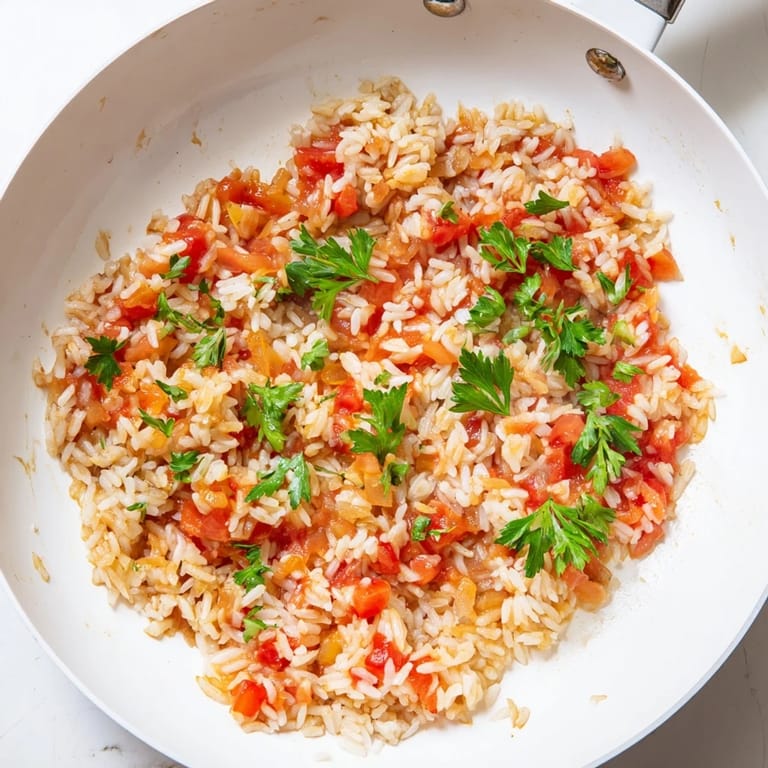This hearty Tomato-Rice Skillet Dinner features fluffy rice and tomatoes, a filling and easy vegetarian main course.
