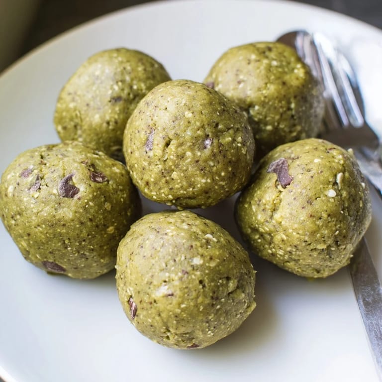 Close-up of freshly made Matcha Gingerbread Cookie Dough Protein Bites, suggesting a delightful, energy-boosting treat.