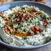 Creamy whipped feta dip with golden honey drizzle, crunchy walnuts, and fresh herbs, served with warm pita and crisp vegetable sticks.